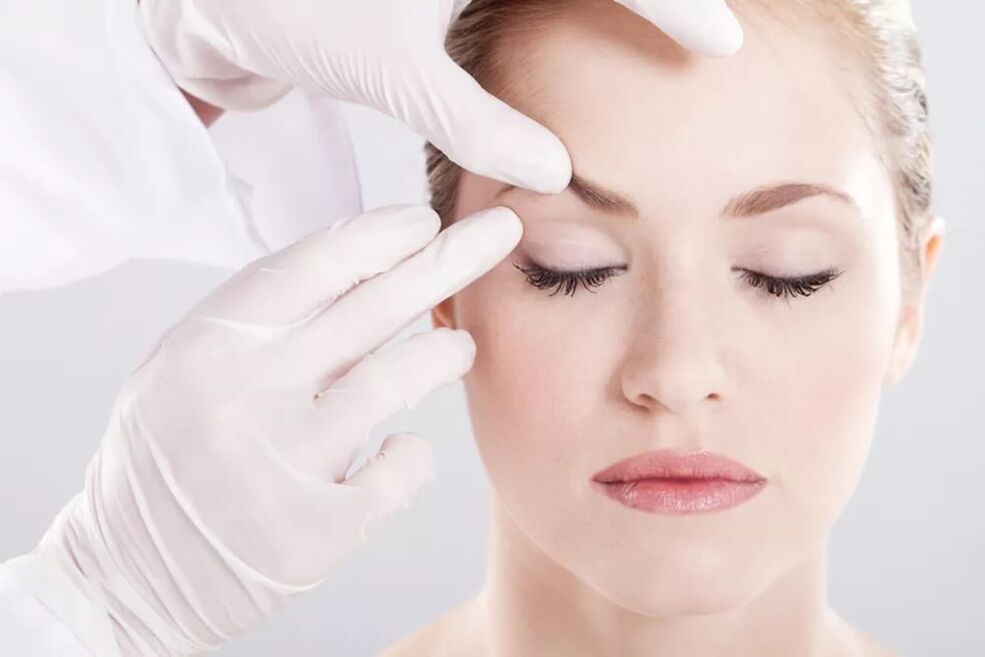 Cosmetologist examines the skin around the eyes